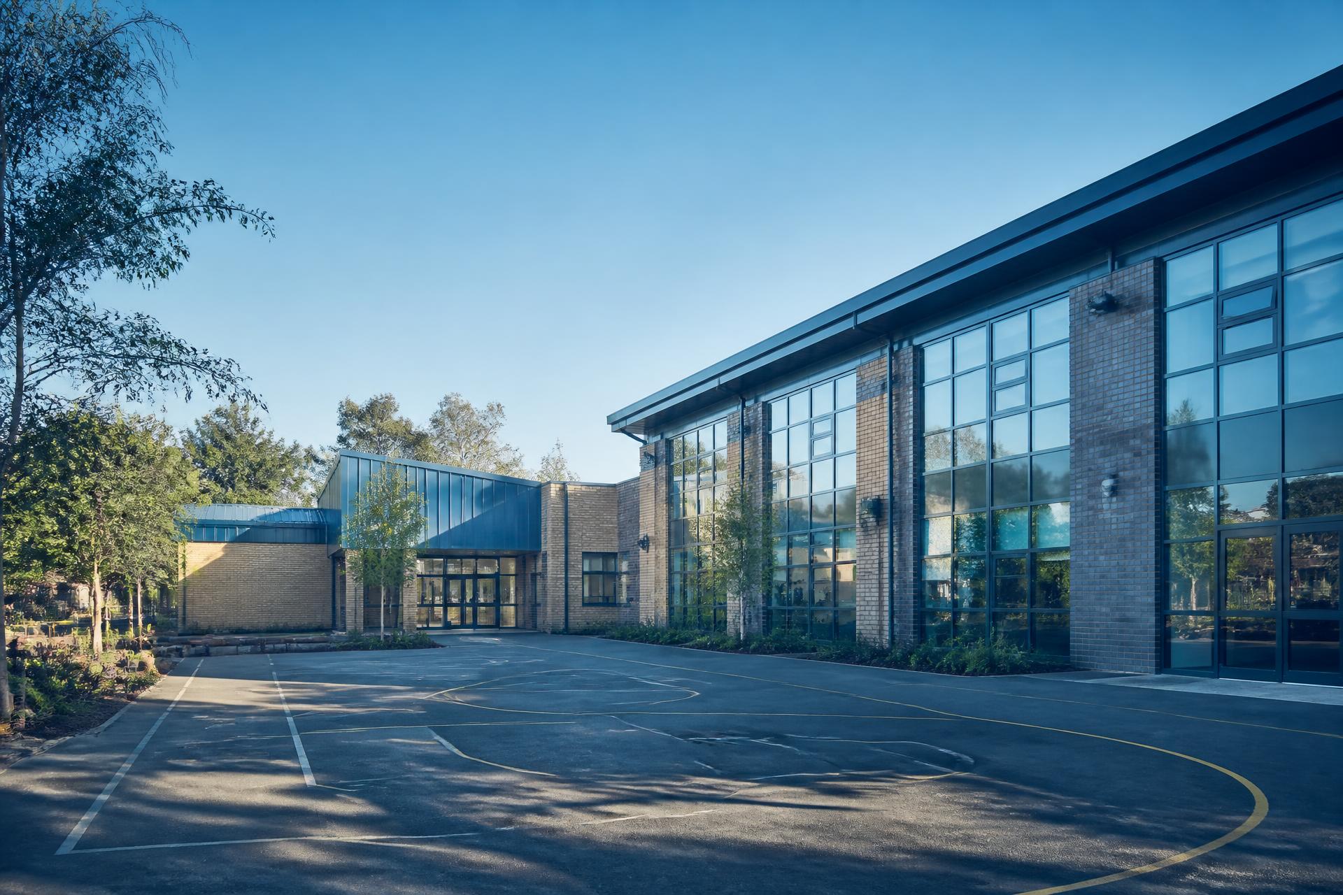 Exterior of a modern UK primary school building and playground on a clear morning